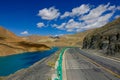 Scenic asphalt road runs along the breathtaking emerald colored Manak Dam Lake.