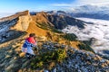 Scenic autumn landscape of Acheshbok rocky mountain peak under blue sky at sunset. Man photographer shooting scenery. West Caucasu Royalty Free Stock Photo