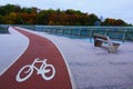 Scenic autumn landscape view of winding red color bike lane with white bicycle sign on the New Pedestrian Bridge in Kyiv, Ukraine Royalty Free Stock Photo