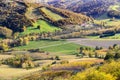 Scenic autumn landscape with yellowed trees, green fields, vineyards, hills and car road Royalty Free Stock Photo