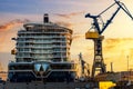 Scenic back view large modern luxury cruise ship liner under construction building cranes at dry dock shipyard in Royalty Free Stock Photo