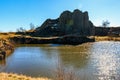 Scenic basalt rock formation with tranquil lake in sunlit landscape Royalty Free Stock Photo