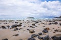 Scenic beach landscape with a serene shoreline with rocks scattered along the golden-hued sand
