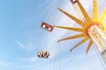 Scenic bottom view high chain swing flying carousel against blue sky. Merry go round roundabout chairoplane at portable