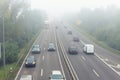 Scenic city highway road traffic jam many cars at foggy misty rainy haze morning low poor visibility cold spring autumn Royalty Free Stock Photo