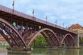 Scenic cityscape of Maribor. Old Bridge against cloudy sky. Metal construction of the bridge.