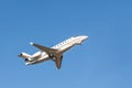 Scenic close bottom view modern luxury expensive white private jet plane dispatching from airport isolated on blue clear Royalty Free Stock Photo