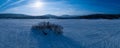 Scenic Close Up Panorama On Frozen Lake, Small Island With Trees, Snow Mobile Traces On Lake, Sunny Blue Sky With Plane Traces