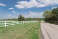 Scenic country road along long white fence leads to horizontal in cloud blue sky in Ennis, Texas, USA Royalty Free Stock Photo