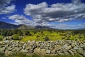 Scenic countryside landscape with a rocky wall, and glacier mountains in the background