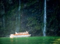 Scenic cruise approaches waterfall, Milford Sound. Royalty Free Stock Photo