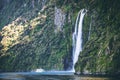 Scenic cruise approaches waterfall, Milford Sound. Royalty Free Stock Photo