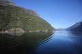 Scenic cruising down geiranger fjord. Beautiful landscape with reflections of the mountains in the water on a calm summer day. Royalty Free Stock Photo