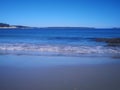 Scenic display of calm sea waves hitting the shoreline with smooth sand