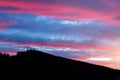 Scenic dramatic fiery cloudy sunset evening view over mountain resort village Bukovel in Ukraine with pine forest christmas tree Royalty Free Stock Photo