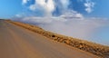 Scenic empty road on high mountain peak viewpoint above sea of clouds, natural stone wall close to abyss Mirador del Rio -