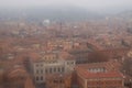 Scenic foggy high perspective view from the tower on Bologna old town center. Vintage buildings with red tile roofs Royalty Free Stock Photo