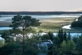 Scenic foggy Ume river delta, national reserve in North Sweden, late summer evening. Forest, pastures, river are covered by thin