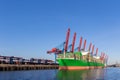 Scenic front giant cargo container ship loading Hamburg city port harbour seaport cranes on clear blue sky day Royalty Free Stock Photo