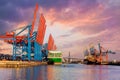 Scenic front giant cargo container ship loading Hamburg city port harbour seaport cranes warm dramatic sky evening Royalty Free Stock Photo