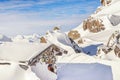 Scenic Highland alpine old abandoned stone hut with chimney snowbound by thick snow layer after blizzard. Mountain