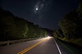 scenic highway at night, with the moon and stars shining overhead