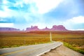 The scenic highway of U.S. Route 163 in Utah leading south to Arizona, through the red rocks of Monument Valley, in white cloud