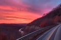 scenic highway with view of the sunrise, with pink and orange hues in the sky