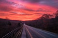 scenic highway with view of the sunrise, with pink and orange hues in the sky