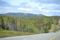 Scenic hilly landscape along Newfoundland highway with cloud filled sky Royalty Free Stock Photo
