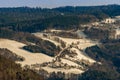 Idyllic Austrian rural winter landscape with snow, hills, valley, trees, road and farm buildings Royalty Free Stock Photo