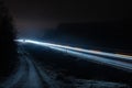 Scenic intensive traffic light trails on motorway in total night darkness, bright car lights. Northern Sweden, Umea.