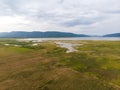 Scenic landscape aerial view of field river and basin against a natural mountain, Drone shot tropical landscape with noise and