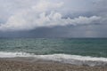 Scenic landscape of the beach and dark blue sea, cloudy sky before a thunderstorm Royalty Free Stock Photo