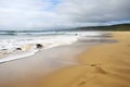 scenic landscape of deserted beach, with waves rolling onto shore Royalty Free Stock Photo