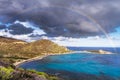 Scenic landscape with a dramatic sky and rainbow over a shore Royalty Free Stock Photo