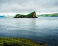 Scenic landscape featuring a small island covered with lush green grass, Umnak, Alaska