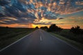 Scenic landscape with an open, empty road with billowing clouds in the sky above Royalty Free Stock Photo