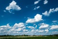 Scenic Landscape with predominant Blue sky, White Clouds and Green Countryside.