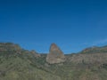 Scenic landscape with Roque de Agando rock at hiking trail through Barranco de Guarimiar Gorge. Green mountain canyon