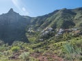 Scenic landscape with Roque de Imada rock and village at hiking trail Barranco de Guarimiar Gorge. Green mountain canyon