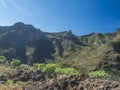 Scenic landscape with Roque de Imada rock and village at hiking trail Barranco de Guarimiar Gorge. Green mountain canyon