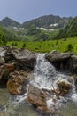 Scenic landscape of snowy mountain in the background and a small waterfall in the foreground