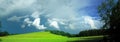 Scenic landscape with storm cloud in background over green agriculture fields Royalty Free Stock Photo