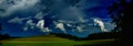 Scenic landscape with storm cloud in background over green agriculture fields Royalty Free Stock Photo