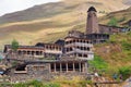 Scenic landscape of summer morning in the Caucasus mountains. Sun just came out and illuminates ancient ruins of Tushetian towers Royalty Free Stock Photo