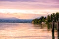 Scenic landscape of sunset with dramatic pink sky and reflection in water on Garda lake in Sirmione, Lombardy, Italy. Beautiful