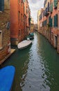 Scenic landscape of typical street canal between ancient buildings in Venice. Boats moored near houses Royalty Free Stock Photo