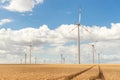 Scenic landscape view of wheat field harvest and big modern wind turbine mill farm against beautiful clouds blue sky Royalty Free Stock Photo