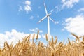 Scenic landscape view of wheat field harvest and big modern wind turbine mill farm against beautiful clouds blue sky Royalty Free Stock Photo